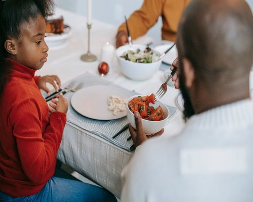 A family dining table beautifully laid with healthy food portions for dinner